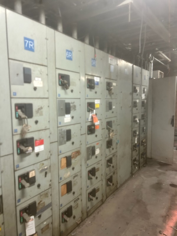 A switchgear line-up landed and terminated, section by section — compartments, breaker handles and the protective devices squared away.