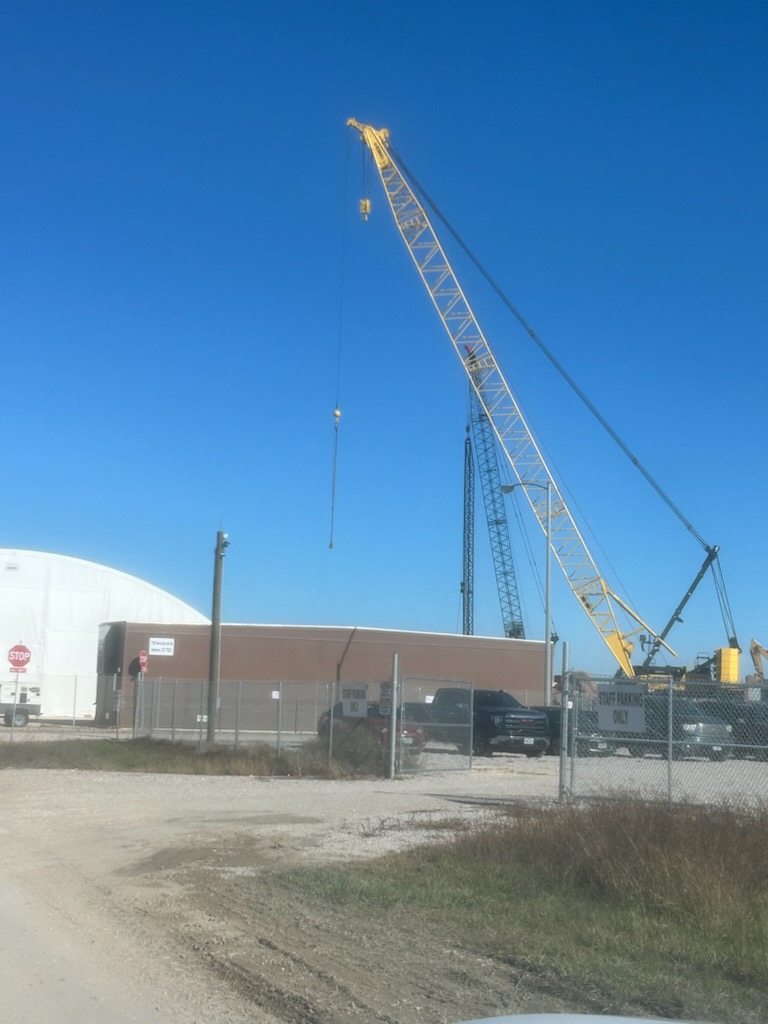 A unit going up under a lattice-boom crane. This is the setting most of our crews work in — the site mid-construction, standing work at scale.